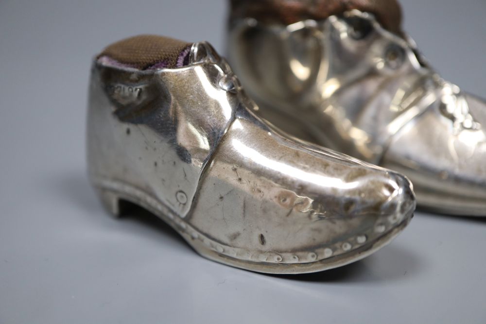 Two early 20th century novelty silver mounted pin cushions, modelled as shoes,